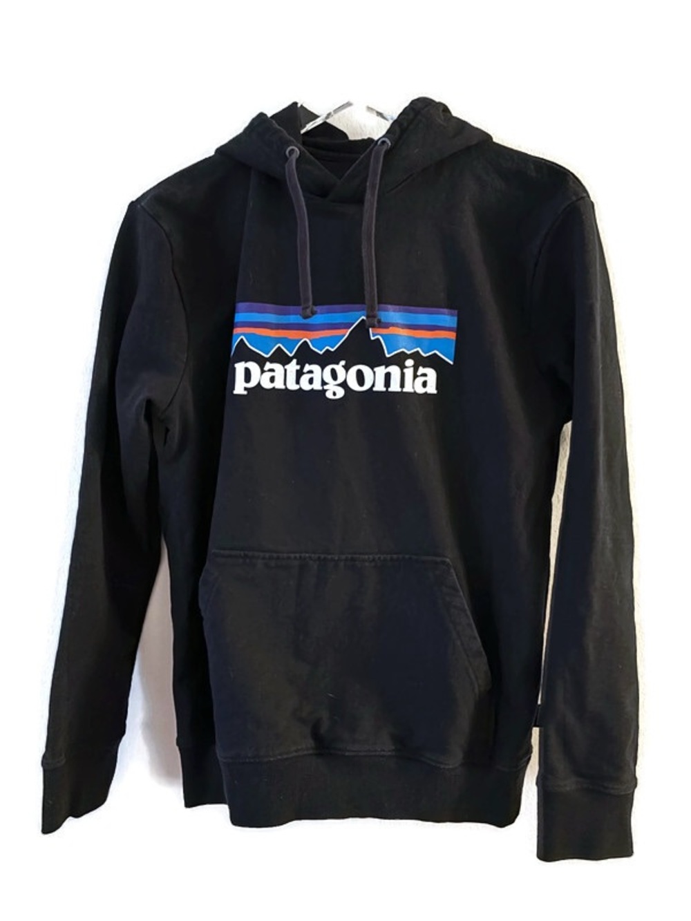 Patagonia black hoodie with blue/orange mountain range logo, size M